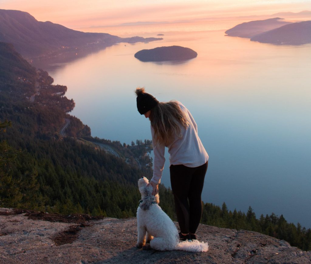 Koira ja nainen retkellä vuoristossa